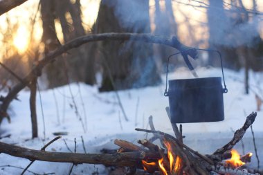 Kış ormanda ateş üzerinde kaynar su bir sürahi sıcak,