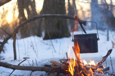 Kış ormanda ateş üzerinde kaynar su bir sürahi sıcak,