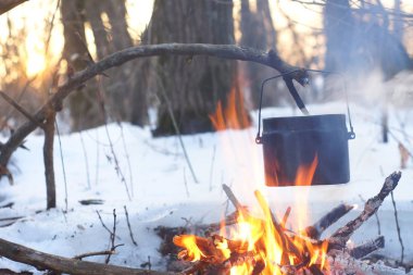 Kış ormanda ateş üzerinde kaynar su bir sürahi sıcak,