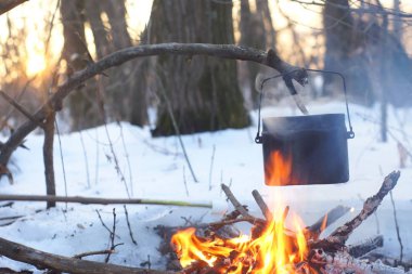 Kış ormanda ateş üzerinde kaynar su bir sürahi sıcak,