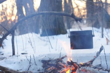 Kış ormanda ateş üzerinde kaynar su bir sürahi sıcak,