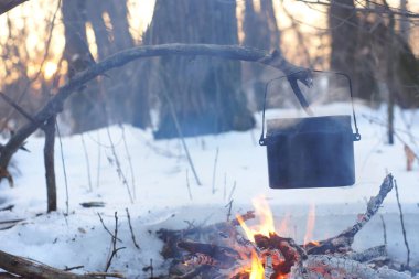 Kış ormanda ateş üzerinde kaynar su bir sürahi sıcak,