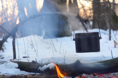 Kış ormanda ateş üzerinde kaynar su bir sürahi sıcak,