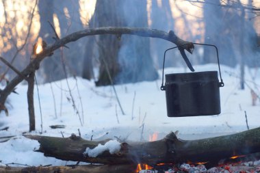 Kış ormanda ateş üzerinde kaynar su bir sürahi sıcak,