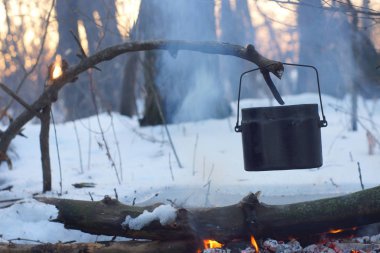 Kış ormanda ateş üzerinde kaynar su bir sürahi sıcak,