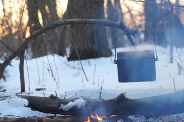 Kış ormanda ateş üzerinde kaynar su bir sürahi sıcak,