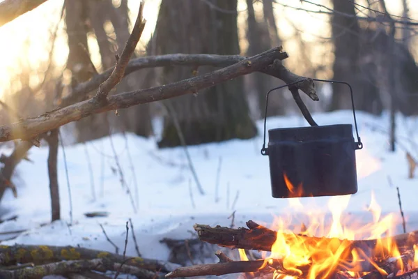 Kış ormanda ateş üzerinde kaynar su bir sürahi sıcak,