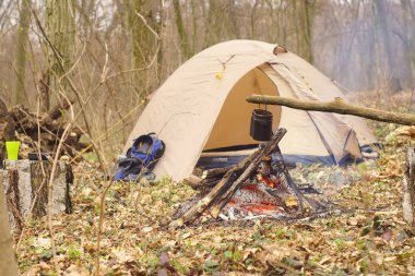 Turist çaydanlığı koyayım kampı ateş ile arka plan üzerinde çadır. fire.a hakkında sopayla el