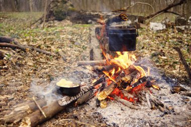 Turist çaydanlığı koyayım kampı ateş ile arka plan üzerinde çadır. fire.a hakkında sopayla el