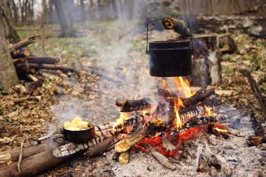 Turist çaydanlığı koyayım kampı ateş ile arka plan üzerinde çadır. fire.a hakkında sopayla el