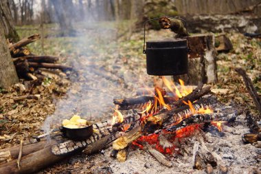 Turist çaydanlığı koyayım kampı ateş ile arka plan üzerinde çadır. fire.a hakkında sopayla el