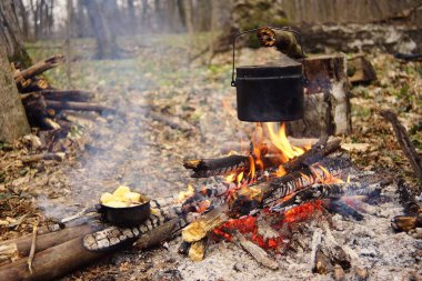 Turist çaydanlığı koyayım kampı ateş ile arka plan üzerinde çadır. fire.a hakkında sopayla el