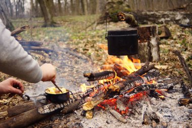 Turist çaydanlığı koyayım kampı ateş ile arka plan üzerinde çadır. fire.a hakkında sopayla el