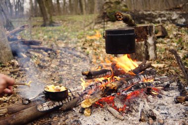 Turist çaydanlığı koyayım kampı ateş ile arka plan üzerinde çadır. fire.a hakkında sopayla el