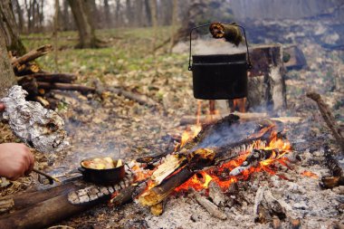 Turist çaydanlığı koyayım kampı ateş ile arka plan üzerinde çadır. fire.a hakkında sopayla el