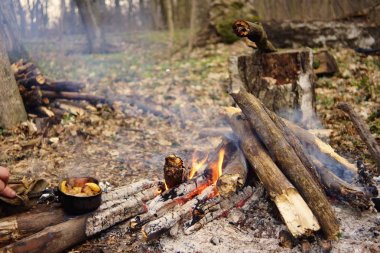Turist çaydanlığı koyayım kampı ateş ile arka plan üzerinde çadır. fire.a hakkında sopayla el