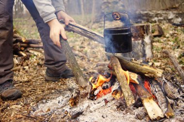 Turist çaydanlığı koyayım kampı ateş ile arka plan üzerinde çadır. fire.a hakkında sopayla el