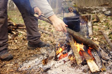 Turist çaydanlığı koyayım kampı ateş ile arka plan üzerinde çadır. fire.a hakkında sopayla el