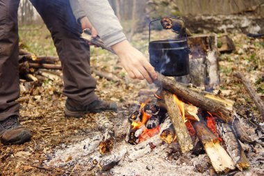 Turist çaydanlığı koyayım kampı ateş ile arka plan üzerinde çadır. fire.a hakkında sopayla el