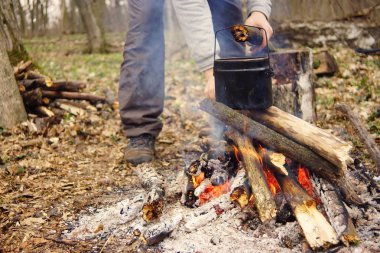 Turist çaydanlığı koyayım kampı ateş ile arka plan üzerinde çadır. fire.a hakkında sopayla el