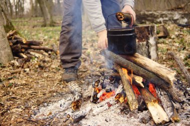 Turist çaydanlığı koyayım kampı ateş ile arka plan üzerinde çadır. fire.a hakkında sopayla el