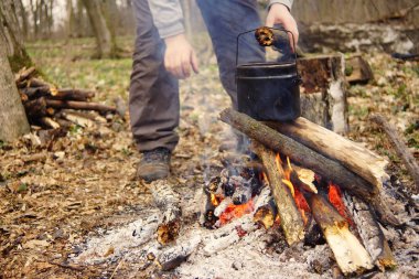 Turist çaydanlığı koyayım kampı ateş ile arka plan üzerinde çadır. fire.a hakkında sopayla el