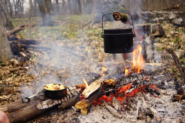 Chaleira turística em fogo acampamento com tenda no fundo. mão com vara sobre fire.a — Fotografia de Stock