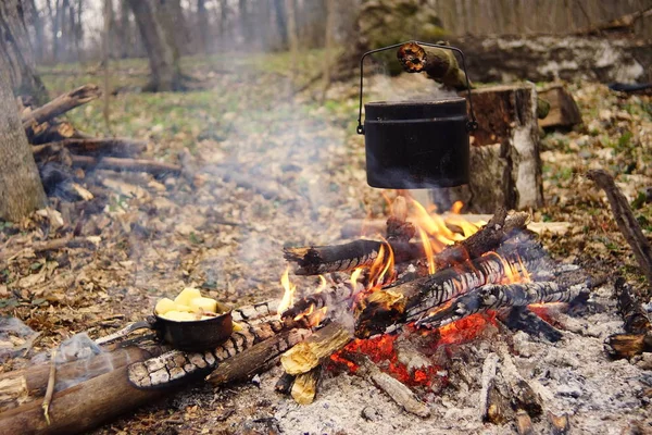 Preparing food on campfire in wild camping as