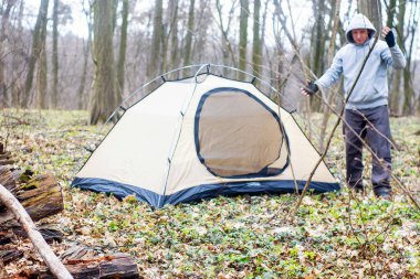 Genç adam ormanda bir çadır koyarak bir