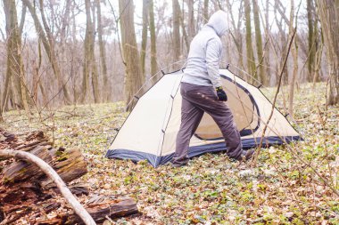 Genç adam ormanda bir çadır koyarak bir