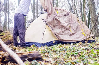 Genç adam ormanda bir çadır koyarak bir