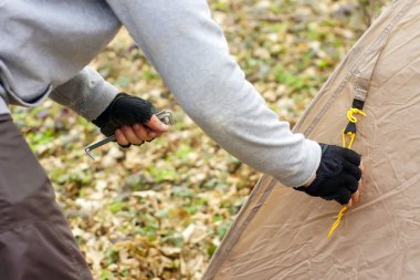 Genç adam ormanda bir çadır koyarak bir