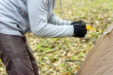 Genç adam ormanda bir çadır koyarak bir