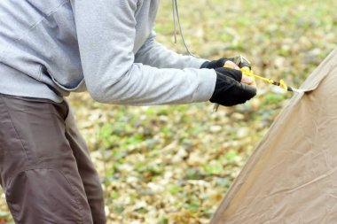 Genç adam ormanda bir çadır koyarak bir