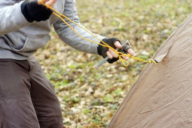 Genç adam ormanda bir çadır koyarak bir