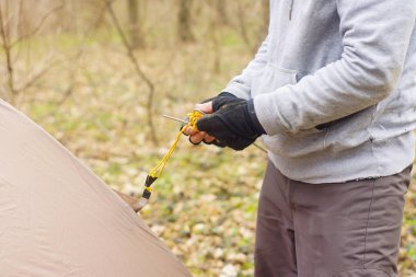 Genç adam ormanda bir çadır koyarak bir