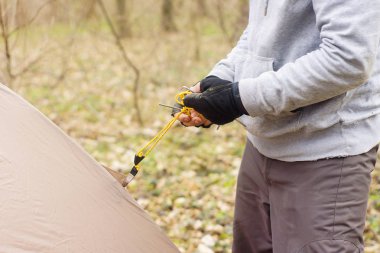 Genç adam ormanda bir çadır koyarak bir