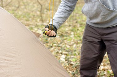 Genç adam ormanda bir çadır koyarak bir