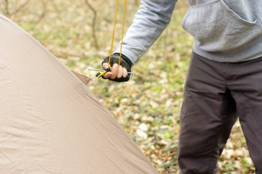Genç adam ormanda bir çadır koyarak bir