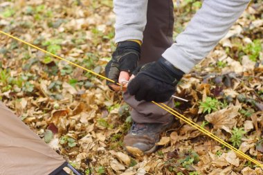 Genç adam ormanda bir çadır koyarak bir
