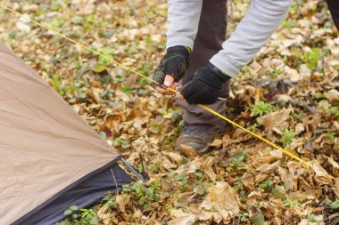Genç adam ormanda bir çadır koyarak bir