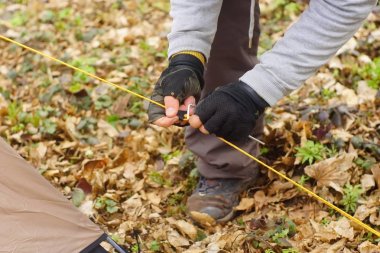 Genç adam ormanda bir çadır koyarak bir