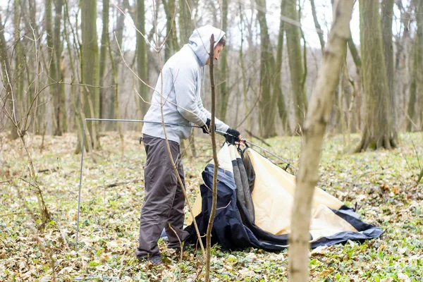 Jonge man zetten een tent in het bos een — Stockfoto