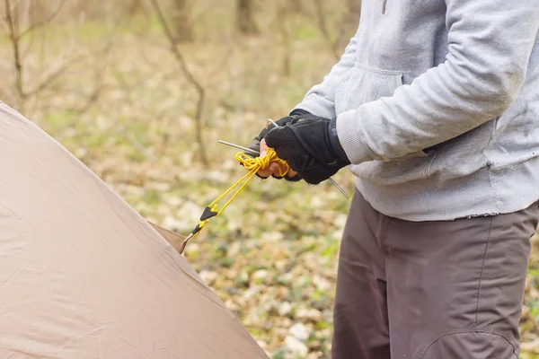 Junger Mann stellt ein Zelt in den Wald — Stockfoto