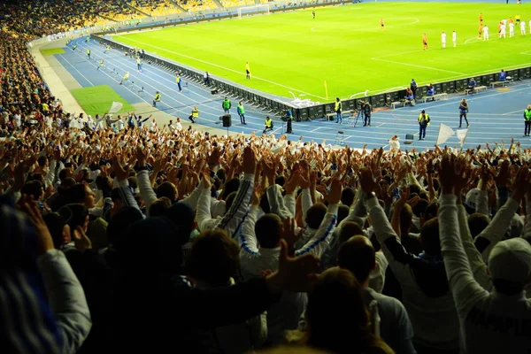 Fussball-Fans unterstützen ihre Mannschaft und feiern Tor im vollen Stadion unter freiem Himmel mit schönem Sky- Blur-Bild. — Stockfoto