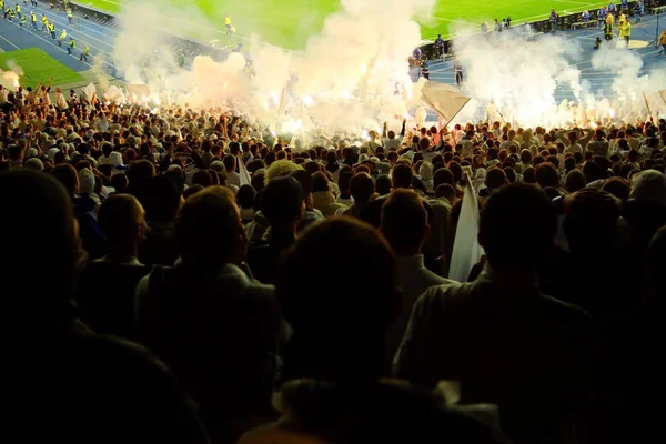 Los fanáticos del fútbol apoyan a su equipo y celebran el gol en el estadio completo al aire libre con un bonito cielo. . — Foto de Stock