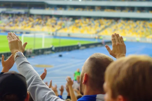 Fussball-Fans unterstützen ihre Mannschaft und feiern Tor im vollen Stadion unter freiem Himmel mit schönem Sky- Blur-Bild. — Stockfoto