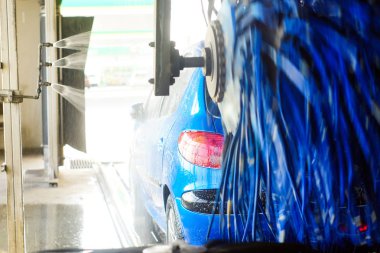 Oto yıkama, siyah arabaya otomatik oto yıkama, kırmızı ve mavi fırça döner. Yıkama araç.