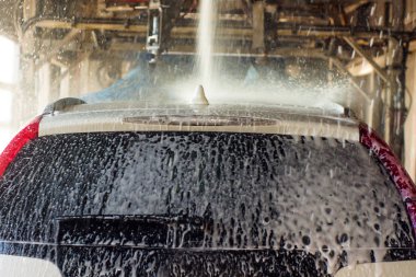 Oto yıkama, siyah arabaya otomatik oto yıkama, kırmızı ve mavi fırça döner. Yıkama araç.