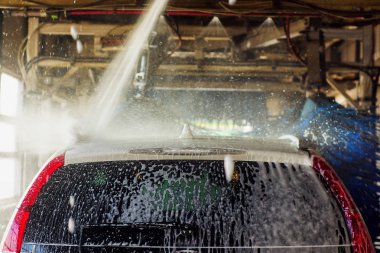 Oto yıkama, siyah arabaya otomatik oto yıkama, kırmızı ve mavi fırça döner. Yıkama araç.